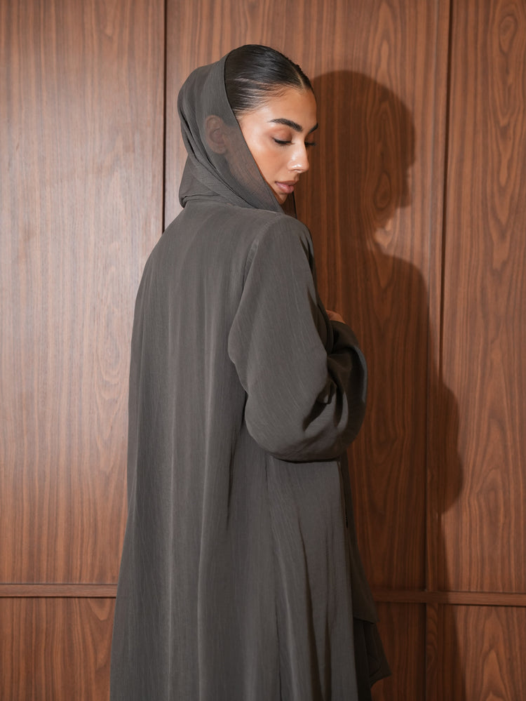 Taupe grey abaya shown from the back with a flowing silhouette